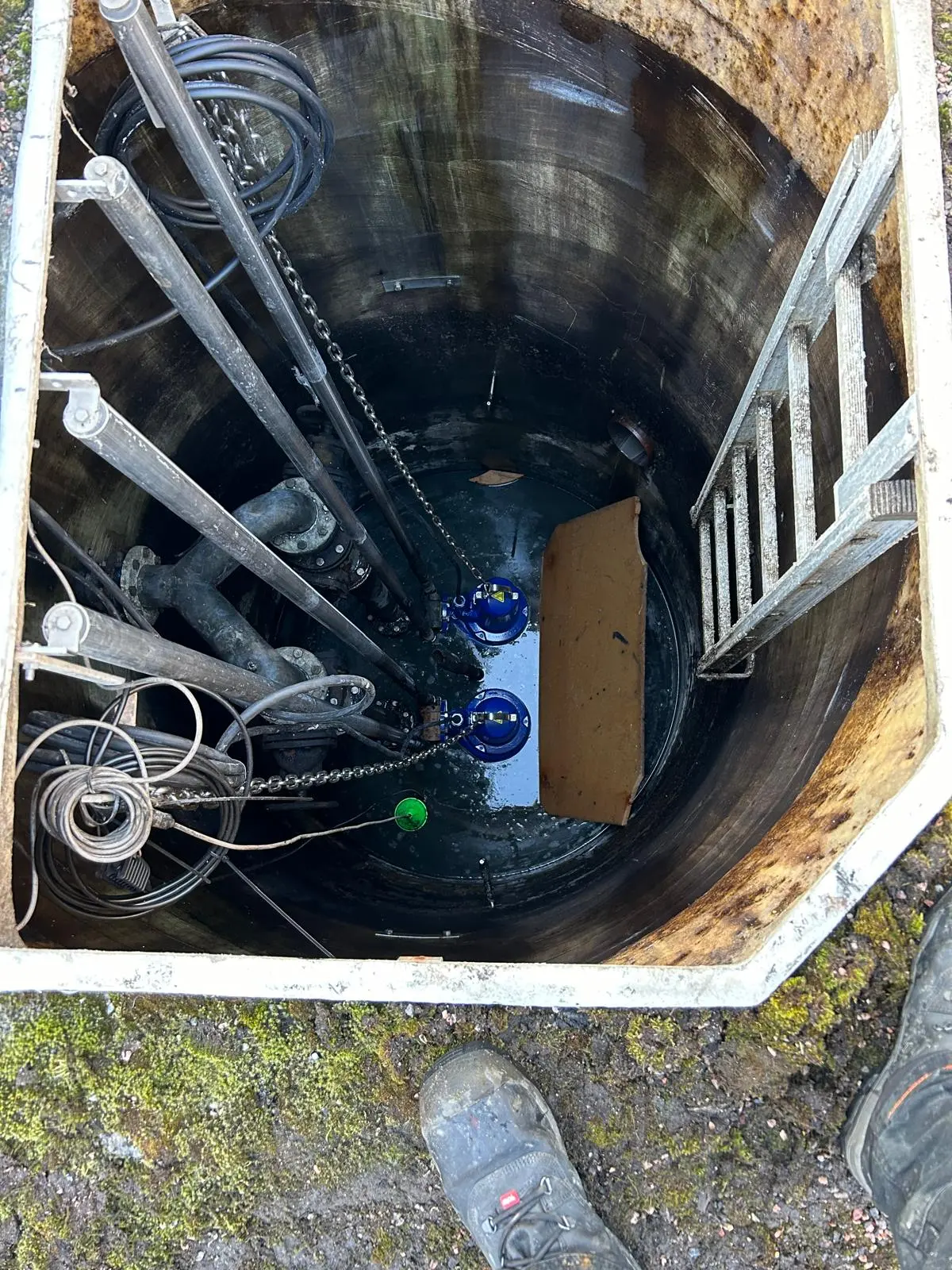 Pumppaamokaivon tikkaat ja putkisto ylhäältä